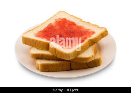 Haufen von geschnittenem Brot mit Erdbeermarmelade in einer Platte auf weißem Hintergrund Stockfoto