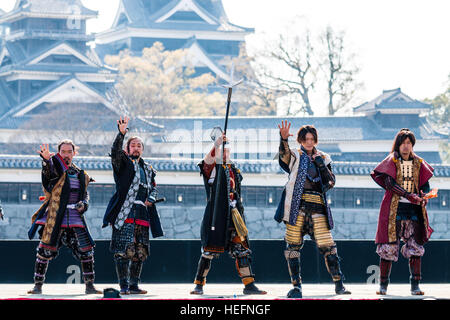 Japanische Yosakoi Festival. Tänzer gekleidet wie Samurai Warriors, kurze Show auf der Bühne mit Kumamoto Schloss im Hintergrund. Stockfoto