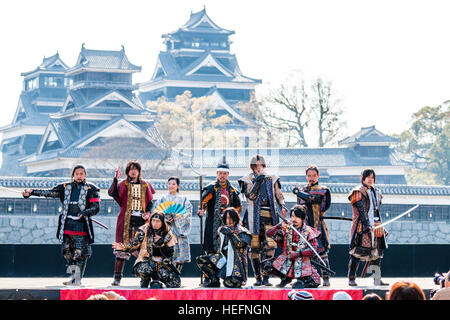 Japanische Yosakoi Festival. Tänzer gekleidet wie Samurai Warriors, kurze Show auf der Bühne mit Kumamoto Schloss im Hintergrund. Stockfoto