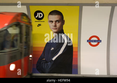 Eine JD Sports-Anzeige am Leicester Square u-Bahnstation wie ein Zug ankommt Stockfoto