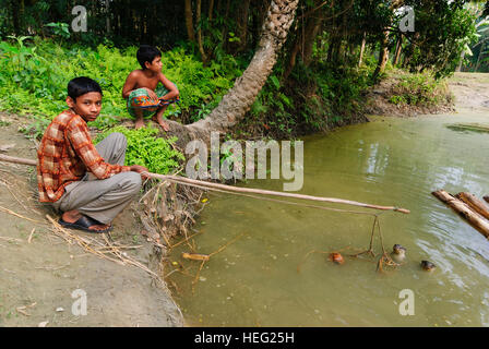 Hariargup: Kinder mit 2 Seil-gebundenen indische Fischotter oder Soft-Fured Fischotter (Lutrogale Perspicillata), die von den Dorfbewohnern zu Laufwerk Fisch in verwendet werden Stockfoto