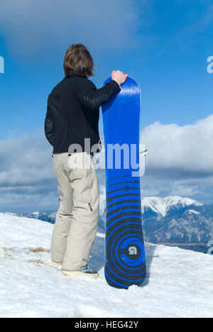 Snowboarder stehen neben Snowboard, Skigebiet Stuhleck, Semmering, Steiermark, Österreich Stockfoto