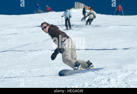 Snowboarder und Skifahrer, Skifahren und Snowboarden einen Abhang hinunter laufen, Skigebiet Stuhleck Semmering, Steiermark, Österreich Stockfoto