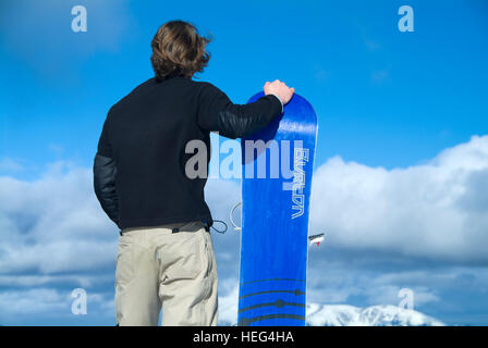 Snowboarder stehen neben Snowboard, Skigebiet Stuhleck, Semmering, Steiermark, Österreich Stockfoto