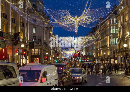 Massen von Weihnachtseinkäufern, die an Weihnachten in London, Großbritannien, entlang einer geschäftigen Regent Street spazieren Stockfoto