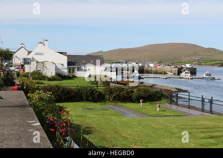 Blick auf Garten, The Skellig Nebel Cafe und am Hafen von Portmagee, County Kerry, Irland Stockfoto