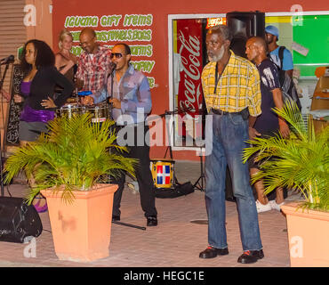 Curaçao, Karibik - 29. September 2012: Straßenkünstler spielen Lieder in Willemstad Curacao. Handelskade mit bunten Fassaden als Hintergrund Stockfoto