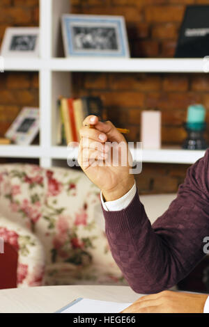 Mann hält Bleistift und schreiben auf dem Papier im Tagebuch Stockfoto