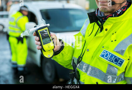 Ein PSNI Straße Polizei-Offizier hält eine operative Alkoholtester während einer zufälligen Alkohol am Steuer-Checkpoint in Belfast. Stockfoto