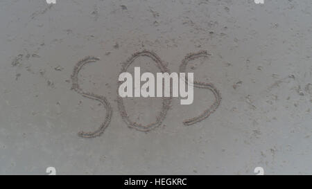 Ansicht von oben Foto von SOS in Sand am tropischen Strand geschrieben. Konzept-Foto der Hilfe Notfall Verzweiflung verloren und Hoffnung Stockfoto