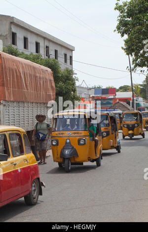 Tuk Tuk Auto Taxis in Verkehr Warteschlange und im Wettbewerb um Kunden. Sambava. Nordosten Madagaskars. Stockfoto