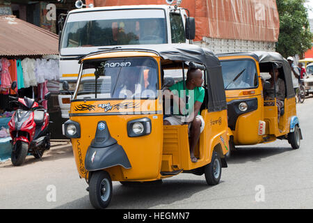 Tuk Tuk Auto Taxis im Wettbewerb um Kunden. Sambava. Nordosten Madagaskars. Stockfoto