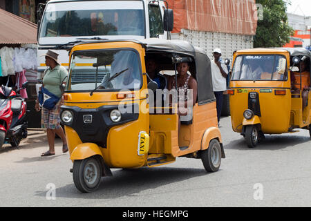 Tuk Tuk Auto Taxis im Wettbewerb um Kunden. Sambava. Nordosten Madagaskars. Stockfoto