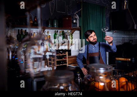 Barkeeper, sauberes Glas im Restaurant Markenphilosophie Barista Arbeit schaut. Stockfoto