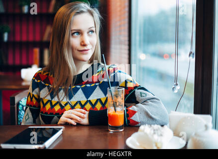 Foto einer Frau trinken Saft durch Fenster Stockfoto