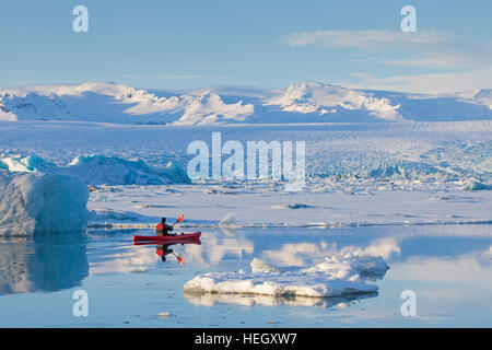 Kajakfahrer in rot Kajak auf der Gletscherlagune Jökulsárlón im Winter, Glazial-See im Südosten Islands Stockfoto