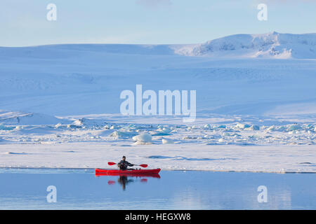 Kajakfahrer in rot Kajak auf der Gletscherlagune Jökulsárlón im Winter, Glazial-See im Südosten Islands Stockfoto