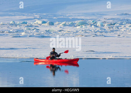 Kajakfahrer in rot Kajak auf der Gletscherlagune Jökulsárlón im Winter, Glazial-See im Südosten Islands Stockfoto