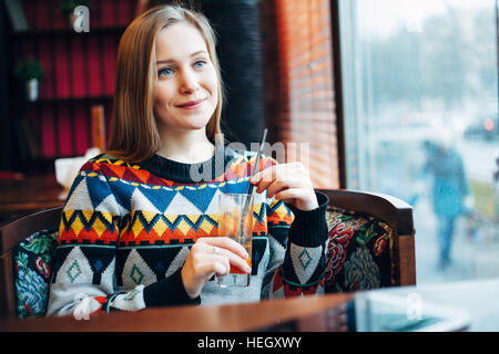Foto einer Frau trinken Saft durch Fenster Stockfoto