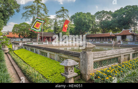 Innenhof mit Pool, Fahnen und traditionelle Gebäude an der Temple of Literature (Van Mieu Quoc Tu Giam), Hanoi, Vietnam Stockfoto