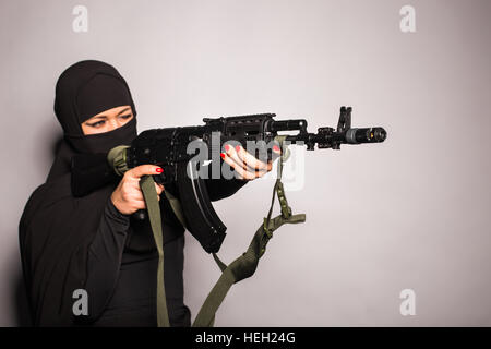 Gefährliche Frau in schwarz mit Sturmgewehr Stockfoto