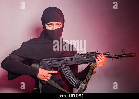 Gefährliche Frau in schwarz mit Sturmgewehr Stockfoto