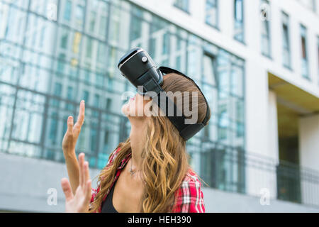 Junge Frau mit High-Tech virtual-Reality-Brille im freien Stockfoto
