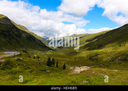 Swiss Alpine Landschaft mit Strasse und Bach Stockfoto