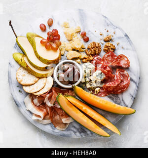 Fleisch und Käse Teller Antipasti snack mit Schinken, Salami, Parmesan, blaue Käse, Cantaloupe-Melone und Oliven auf Marmor board Stockfoto