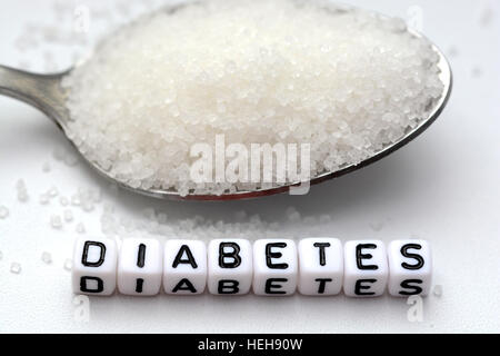 Plastische Buchstaben Perlen Schreibweise "Diabetes" in einen Löffel voll Zucker Stockfoto
