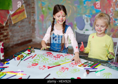 Kleine Gruppe von Mädchen machen Palm druckt auf Papier Stockfoto