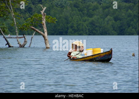Frau trägt ein frachtboot. Fischerdorf auf dem Wasser. Mengkabong Fluss, Kota Kinabalu, Sabah, Borneo, Malaysia. 22 Jun 2012 Stockfoto
