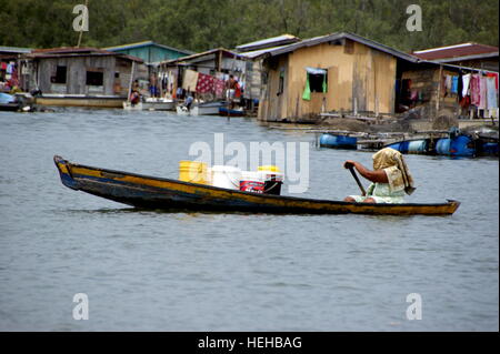 Frau trägt ein frachtboot. Fischerdorf auf dem Wasser. Mengkabong Fluss, Kota Kinabalu, Sabah, Borneo, Malaysia. 22 Jun 2012 Stockfoto