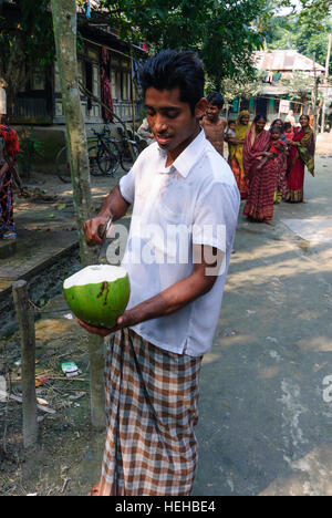 Madhabpasa: Haus im Dorf; Öffnen Sie eine Kokosnuss trinken, die Kokosnuss Wasser, Barisal Division, Bangladesch Stockfoto