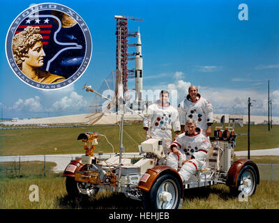 NASA Apollo 17 Mondlandung Mission Prime Crew Astronauten (L-R) Harrison Schmitt, Gene Cernan und Ronald Evans Praxis Betrieb einen Lunar Roving Vehicle-Trainer mit dem Raumschiff Apollo 17 Saturn V im Hintergrund am Kennedy Space Center 30. September 1971 in der Nähe von Merritt Island, Florida. Stockfoto