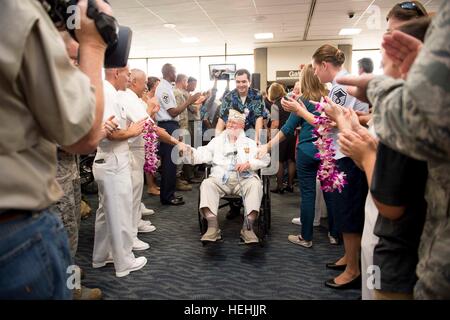 Eine Veteran des zweiten Weltkriegs Pearl Harbor USA wird von US-Soldaten mit floralen Leis begrüßt, nach der Ankunft am internationalen Flughafen Honolulu zur Teilnahme an Veranstaltungen zum Gedenken zu Ehren des 75-jährigen Bestehens des Pearl Harbor Angriffen 3. Dezember 2016 in Honolulu, Hawaii. Stockfoto