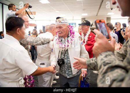 Eine Veteran des zweiten Weltkriegs Pearl Harbor USA wird von US-Soldaten mit floralen Leis begrüßt, nach der Ankunft am internationalen Flughafen Honolulu zur Teilnahme an Veranstaltungen zum Gedenken zu Ehren des 75-jährigen Bestehens des Pearl Harbor Angriffen 3. Dezember 2016 in Honolulu, Hawaii. Stockfoto