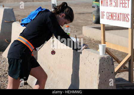 US Army 1st Lt. Kathryn Walker von Iowa City, Iowa, zugewiesene 70. Ingenieure, 555. Ingenieur-Brigade, Multi-National Division - Bagdad, erstreckt sich nach Abschluss einer 25th Infantry Division gesponsert Marathon am Camp Taji, Irak, Dez 14 statt. Honolulu Marathon am Camp Taji 138446 Stockfoto