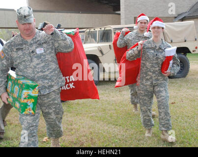 HAMMOND, Louisiana – Louisiana Nationalgarde Soldaten Sgt 1. Klasse Erik A. Vorhoff von Metairie, Louisiana, Spc. Sarah R. Garza Belle Chasse, Louisiana, und Pvt. 1. Klasse Gary W. Linam von Baton Rouge, Louisiana, Spenden Säcke gefüllt mit Spielzeug, die Louisiana Schule für Gehörlose in Baton Rouge, Louisiana, Dez. 18.  204. Flugplatz Operationen Theatergruppe in Hammond, Louisiana, gesammelt über 100 Spielzeug zu spenden, um die Elementar Jungen und Mädchen Schlafsäle.  (US Armee-Foto von Staff Sgt Stephanie J. Cross, staatliche Aviation Command Unit Public Affairs Vertreter) Gardisten verbreitet Weihnachtsstimmung in Louisiana Schule Stockfoto