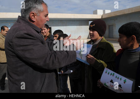 US-Soldaten liefern Zeichnungen von amerikanischen Kindern an eine Schule in Samarra, Irak, und unterstützen ein Pen PAL-Programm, das den kulturellen Austausch und das Engagement der Gemeinschaft fördert. Stockfoto