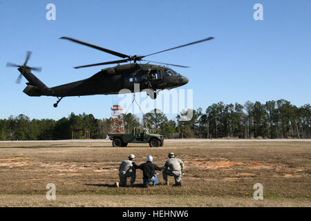 Soldaten mit der 168. Ingenieur-Brigade von Vicksburg, Mississippi stehen durch, nachdem sie den Humvee an den UH-60 Black Hawk-Hubschrauber im Verlauf Sling Last Inspektor Zertifizierung im Lager Shelby Joint Forces Training Center am 9. Jan. angeschlossen. Army National Guard Brigade bereitet sich auf ihre ersten Berg Sturm 145841 Stockfoto