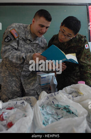 US Armee Sgt. Matthew Frost, eine Apotheke Techniker zugewiesen Tripler Army Medical Center, Hawaii und Japan Ground Self-Defense Force Apotheker, 1st Lt. Kazuhiro Mizuki, gehen über Medikamente am ersten medizinischen Civic Assistance Program Standort an der Baan Kroeng Kra Reaon School in der Provinz Kanchanaburi, Thailand, zur Unterstützung der Übung Cobra Gold 10, 1. Februar. Dies war die erste von sieben MEDCAP Websites im Laufe der Übung geplant. MEDCAP Websites bringen zusammen Ärzte, Zahnärzte und Tierärzte von den Streitkräften der Republik, Indonesien, Japan, Singapur Stockfoto