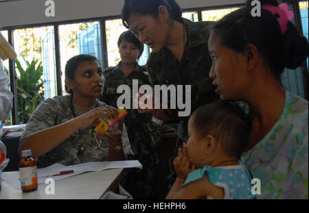 US-Armee Dr. (MAJ) Saro Verghese, pädiatrische Arzt zugewiesen Tripler Army Medical Center, Hawaii, und Royal Thai navy Commander Nongluck Punyasirikulchai, Apotheker, verzichten, Medikamente zu einer Mutter für ihr Kind am ersten medizinischen Civic Assistance Program Standort an der Baan Kroeng Kra Reaon School in der Provinz Kanchanaburi, Thailand, zur Unterstützung der Übung Cobra Gold 10, 1. Februar. Dies war die erste von sieben MEDCAP Websites im Laufe der Übung geplant. MEDCAP Websites bringen zusammen Ärzte, Zahnärzte und Tierärzte aus den Streitkräften von Indonesien, Japan, S Stockfoto