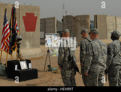 Soldaten von Firma B, 1. Bataillon, 111. Infanterie, 56. Stryker Brigade Combat Team, Pennsylvania National Guard, zollen, Staff Sgt Mark Baum nach einer Trauerfeier, 26. Februar um gemeinsame Sicherheit Station Mushada, etwa 30 Meilen nördlich von Bagdad. Baum starb 21. Februar nach einer Verwundung in einem Kampfgeschehen an diesem Tag. Er war der 33. Pennsylvania Nationalgarde Soldat im Irak oder in Afghanistan seit 9/11 zu sterben. Gedenkfeier 154223 Stockfoto