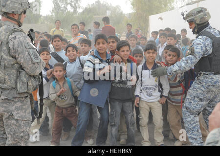 Eine große Menschenmenge der irakischen Kinder versammeln sich außerhalb einer Schule in Shawra Wa Umm Cıdır, östlichen Bagdad, Irak, am 8. März. Irakische nationale Polizei und Soldaten der Bravo Company, 2. Bataillon, 505. Fallschirm-Infanterie-Regiment, 3rd Brigade Combat Team, 82nd Airborne Division, besuchen Schulen und Schulmaterial zu verteilen. Soldaten, irakische nationale Polizisten verteilen Schulmaterial in Bagdad 157267 Stockfoto