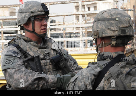 US Army Colonel Timothy McGuire, Kommandeur der 3. Brigade Combat Team, 82nd Airborne Division, Gespräche mit US-Soldaten von A Truppe, 5. Staffel, 73. Kavallerie-Regiment, 3rd Brigade Combat Team, 82nd Airborne Division an der äußeren Sicherheit Kordon um die Szene von Kämpfen zwischen irakischen Sicherheitskräfte und abtrünnigen Mitglieder der Söhne des Irak, im Stadtteil Al-Fadhel östlichen Bagdad , Irak, am 29. März 2009. Patrouille in Bagdad 169424 Stockfoto