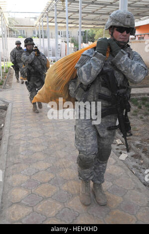 Fallschirmjäger zugewiesen, Headquarters und Headquarters Troop, 5th Squadron, 73. Kavallerie-Regiment, 3rd Brigade Combat Team, 82nd Airborne Division, Multi-National Division-Bagdad, Tragetaschen von Fußball Ausrüstung und andere waren an den Gemeinderat Hauptquartier während einer humanitären Mission 19 Mai in der Stadt Idrissi befindet sich im Stadtteil Rusafa von östlichen Bagdad. Fallschirmjäger, zusammen mit zivilen Angelegenheiten Soldaten zum 401. Civil Affairs Bataillon, zugewiesen haben, Fußball Ausrüstung über östlichen Bagdad zur Unterstützung der FC Einheit, eine monatelange Mühe Abschlussball gereicht Stockfoto