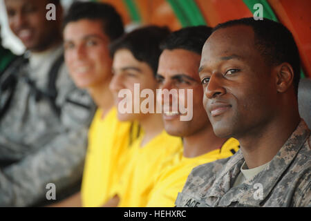 US Armee Sgt. 1.. Klasse Kevin Pace (rechts) aus Philadelphia, Pennsylvania, der 1. Kavallerie-Division, beobachtet das Spiel mit irakischen Fußball-Spieler am Rande des Sha'ab-Stadion in östlichen Bagdad, Irak, am 23. Mai 2009. US-Soldaten der 3. Brigade Combat Team, 82nd Airborne Division und irakische nationale Polizist beteiligen sich an einem öffentlichen Fußballturnier gesponsert von der FC-Einheit-Organisation. Fußballturnier in Bagdad 176410 Stockfoto