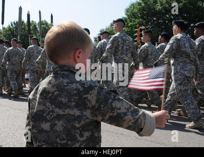 Ein kleiner Junge "Wellenlinien" eine amerikanische Flagge als 1st Infantry Division Soldaten während der Sonnenuntergang Salute Parade in Junction City, Kansas, 4 Juli bis März. Sonnenuntergang Salute ist die größte kostenlose Independence Day Feier im Bundesstaat Kansas. (Foto: U.S. Army Mollie Miller, 1. inf div. Public Affairs) Flickr - der US-Armee - Sonnenuntergang Salute Parade Stockfoto