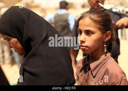 Eine Mutter und Tochter warten geduldig auf ihre Namen während einer humanitären Hilfe-Mission unterstützt durch US-Soldaten zugewiesen Golf Batterie, 82. Feldartillerie-Regiment, 3. Bataillon, 2nd Brigade Combat Team, 1. Kavallerie-Division in Adalla, Irak, Aug. 9 aufgerufen werden. Humanitären Hilfe Mission 195286 Stockfoto